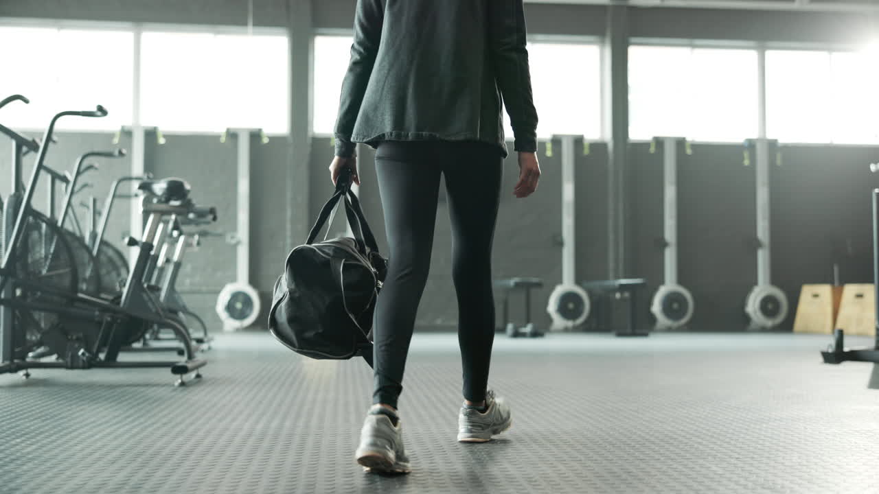 Woman walking with gym bag in a gym