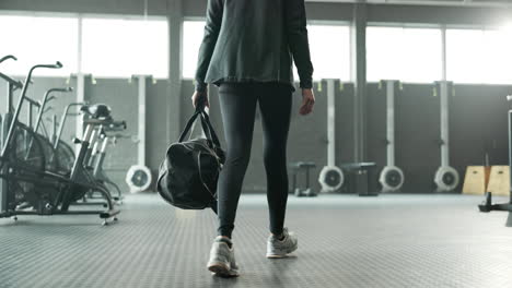 woman walking with gym bag in a gym