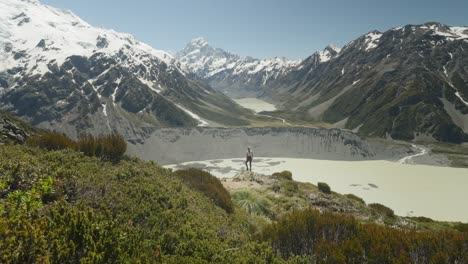 woman on sealy tarns trail with view of mueller lake and mount cook, nz