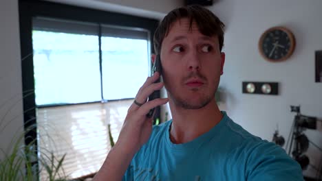 man at home showing varied facial expressions and gestures during phone call, revealing emotions. closeup shot