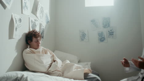 psychiatrist visiting young patient with mental disorder in seclusion room