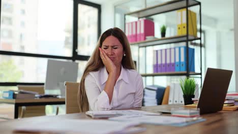 Woman Experiencing Toothache at Her Office Desk