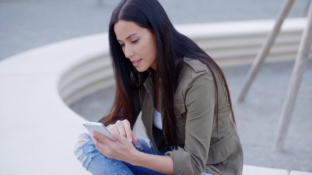 una mujer joven y bonita leyendo un sms.