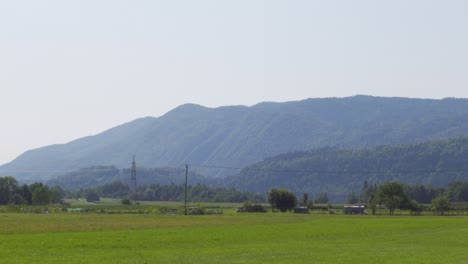 an open and wide meadow in the middle of the alps