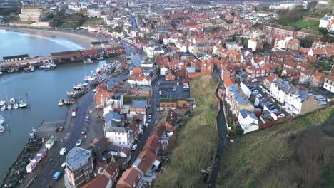 Luftparallaxenaufnahme-Der-Wunderschönen-Stadt-Scarborough-Im-Norden-Von-Yorkshire-Neben-Einem-Hafen-Mit-Booten-Tagsüber-In-England