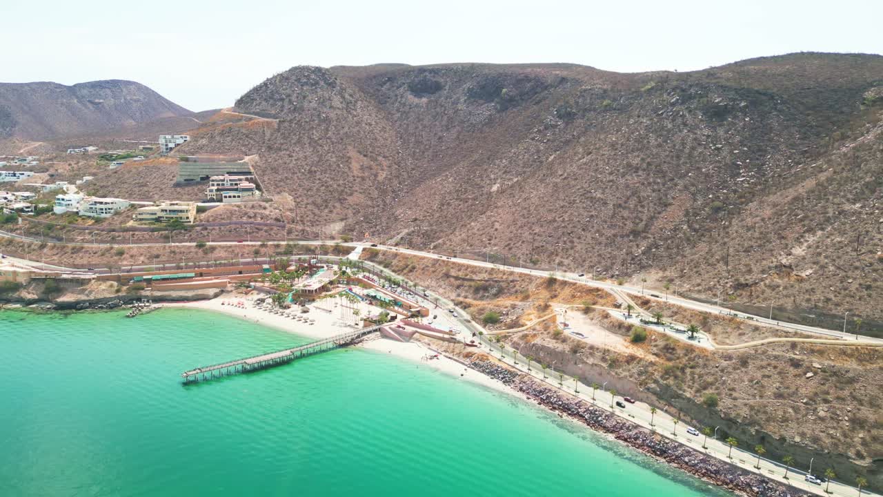 Playa coromuel, la paz, showing beach, pier, and mountains, aerial view