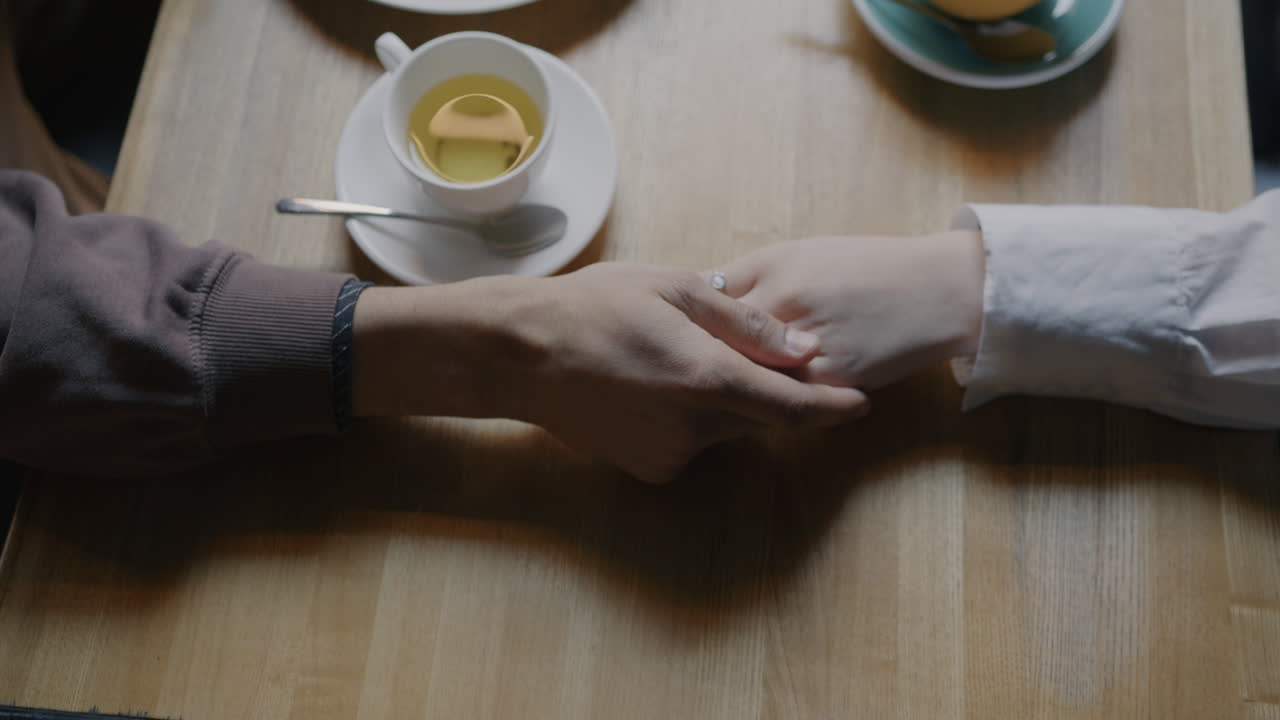 Couple Holding Hands in a Cafe