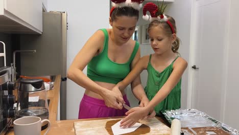 madre y hija horneando galletas de pan de jengibre para navidad
