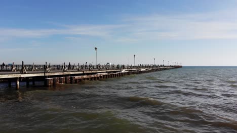 Eine-Niedrige-Luftaufnahme-Von-Menschen,-Die-Im-Spätherbst-Auf-Einem-Lake-Huron-Pier-Fischen