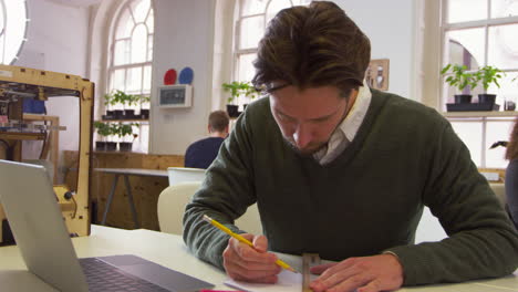 designer drawing a sketch in 3d print design studio, shot on r3d