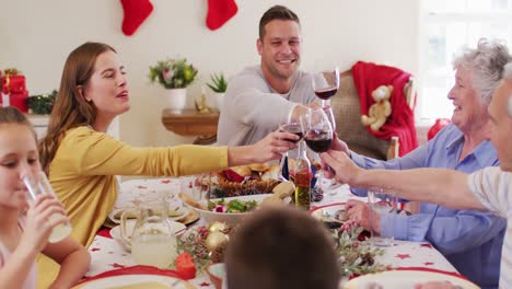 familia caucásica brindando mientras está sentada en la mesa de comedor