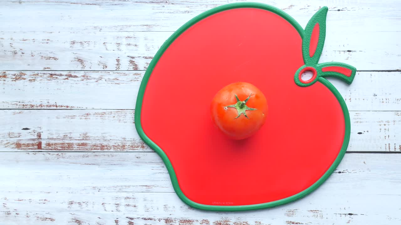 빨간 사과 모양의 절단판에 있는 토마토