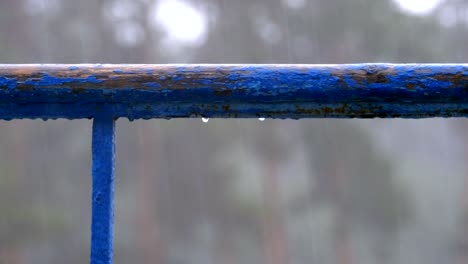 water droplets that drip with windows, balconies or railing against the background of the street where there is rain