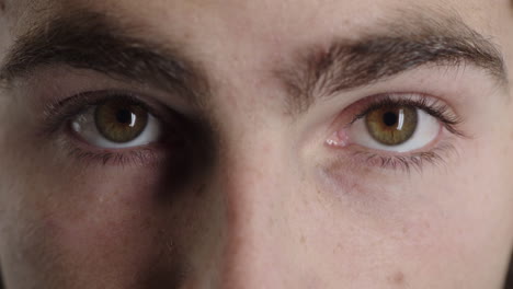 close up man green eyes opening caucasian male awake looking at camera iris focus macro