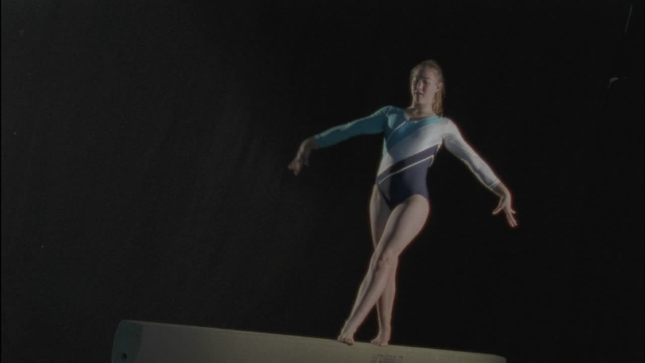 una mujer realiza una rutina en una barra de equilibrio