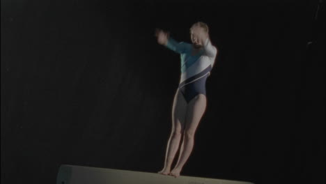 a woman performs a routine on a balancing bar