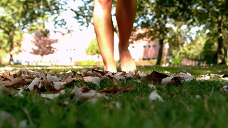 Female-feet-walking-on-leaves