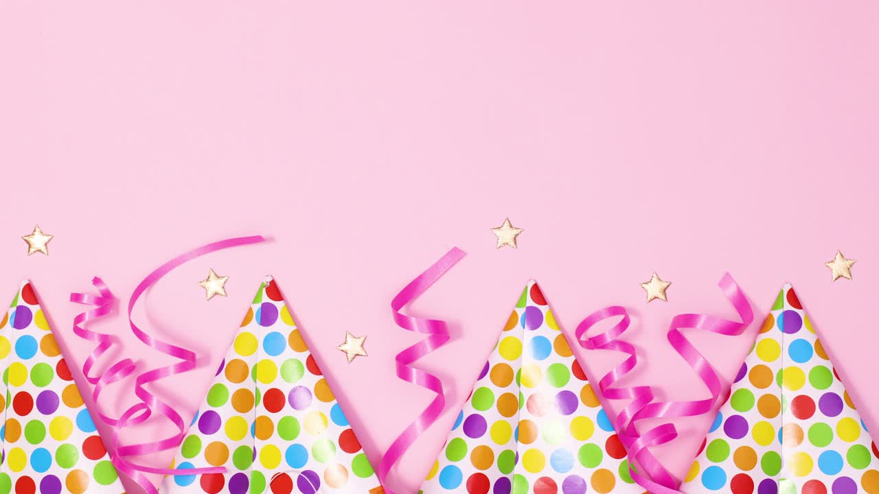 Party caps and ribbons appear on bottom of pastel pink theme. Stop motion