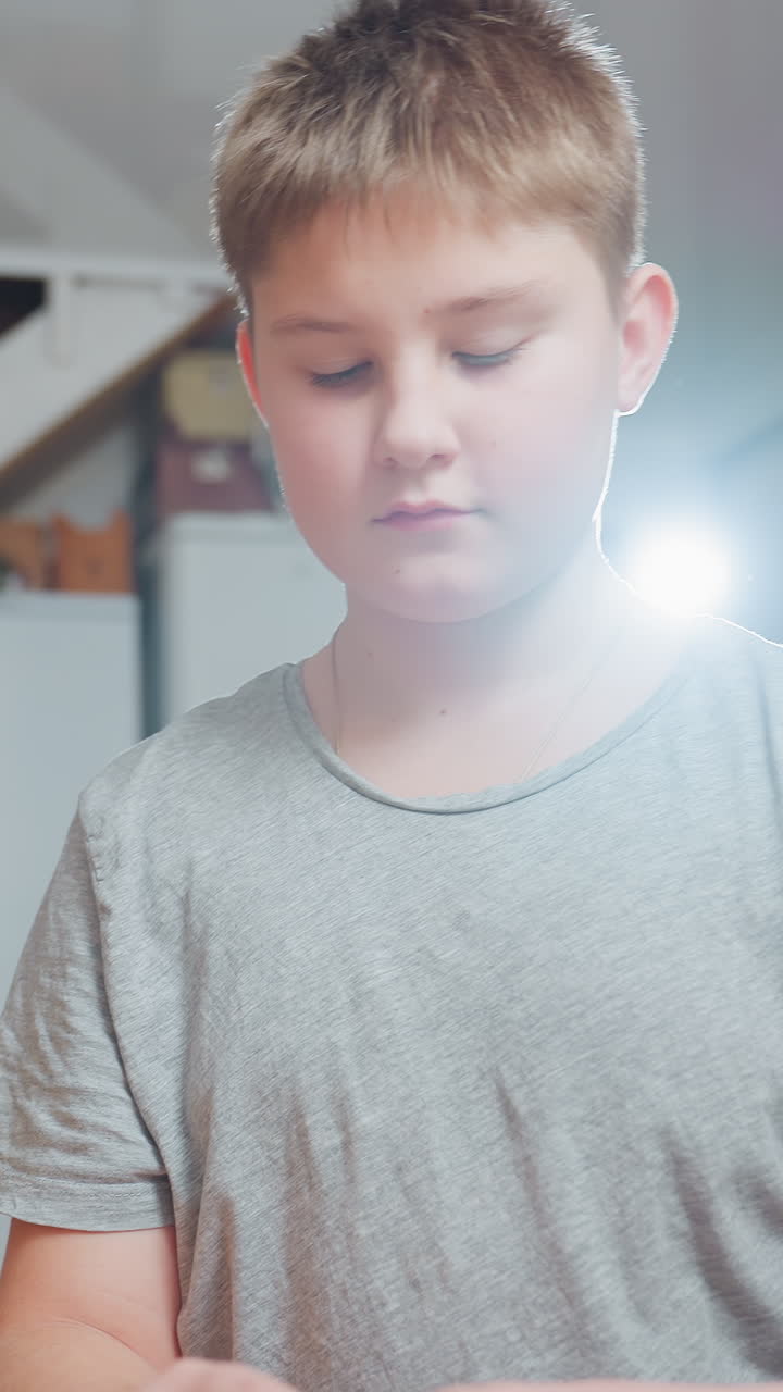 white boy examining wooden box Christmas, curious preteen explores vintage keepsake near decorated tree, warm lens flare backlight, focused expression, careful hands opening box, cozy indoor