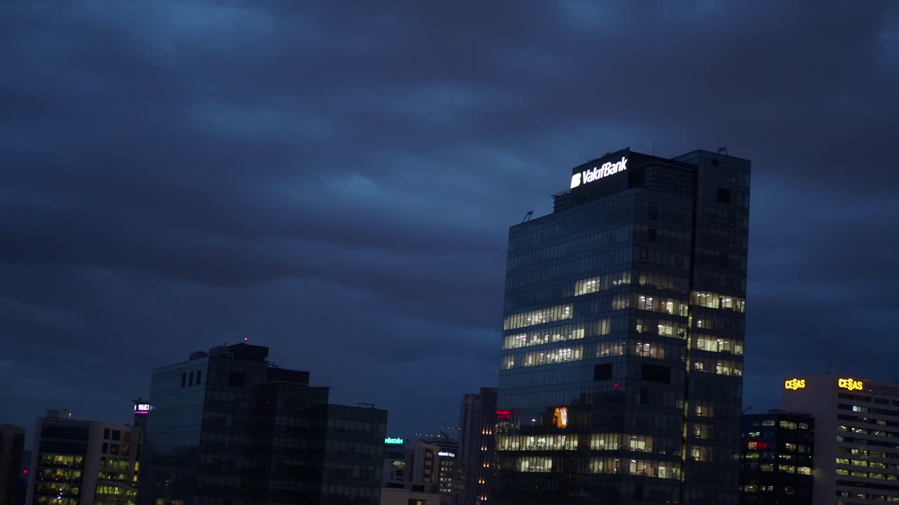 una vista del horizonte de una ciudad por la noche con nubes en el cielo