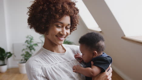retrato de uma mãe amorosa segurando um filho recém-nascido em casa em um apartamento no sótão