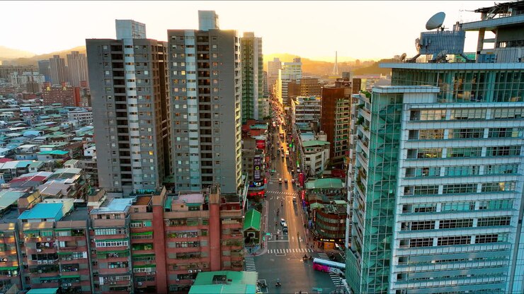 Vista aérea de um complexo de vários blocos de apartamentos na cidade central de Taipé, com tráfego na estrada e um pôr do sol brilhante no horizonte - Bela paisagem urbana de uma cidade asiática.