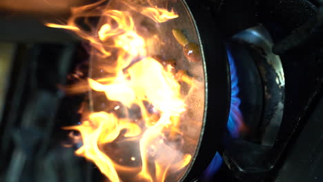 cooking mushroom in a cooking pan while flames are coming up