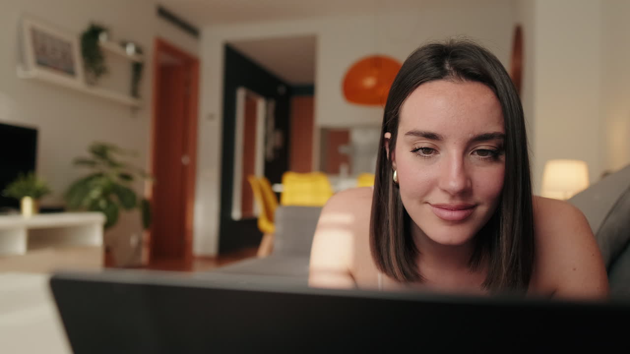 Pretty Woman Browsing on Laptop at Home on Sofa