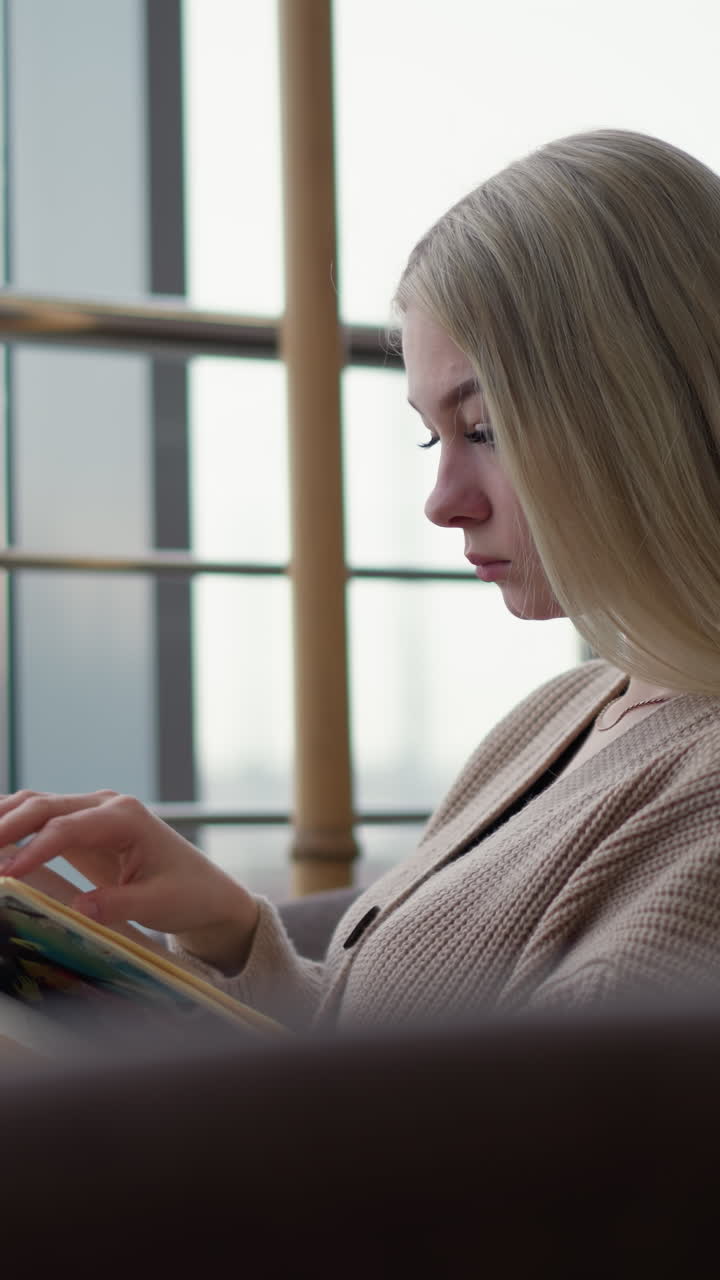 vista lateral de una señora estudiando profundamente, centrada en la lectura de un libro abierto, tranquilamente inmersa en sus pensamientos, con una expresión serena y contemplativa