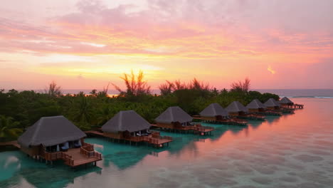 overwater bungalows at sunset in a tropical paradise