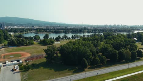 aerial - zagreb city with jarun lake shoreline and baseball field framed by trees and hills