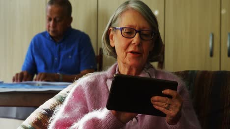 mujer mayor usando tableta digital en la sala de estar 4k