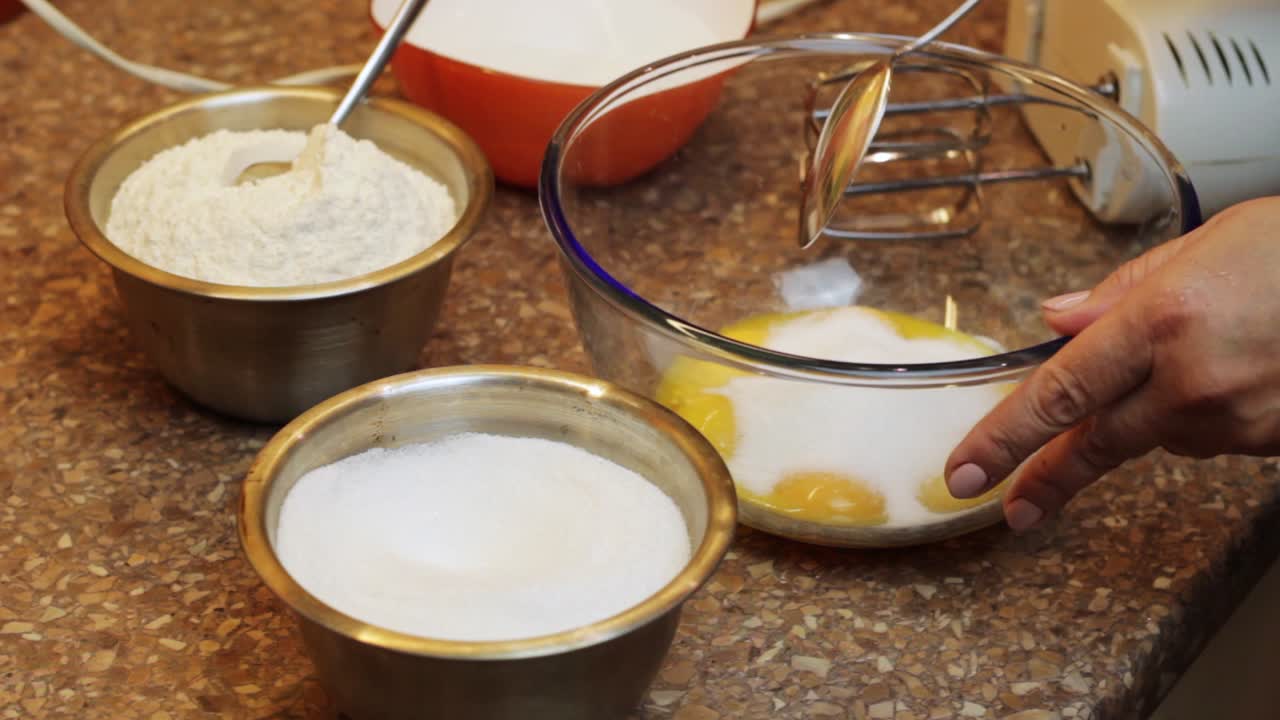 agregando azúcar blanca granulada a las yemas de huevo para la mezcla de masa para pasteles