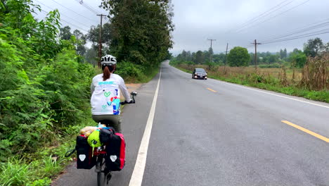 rear view of women riding cycle in the road of nan province, thailand