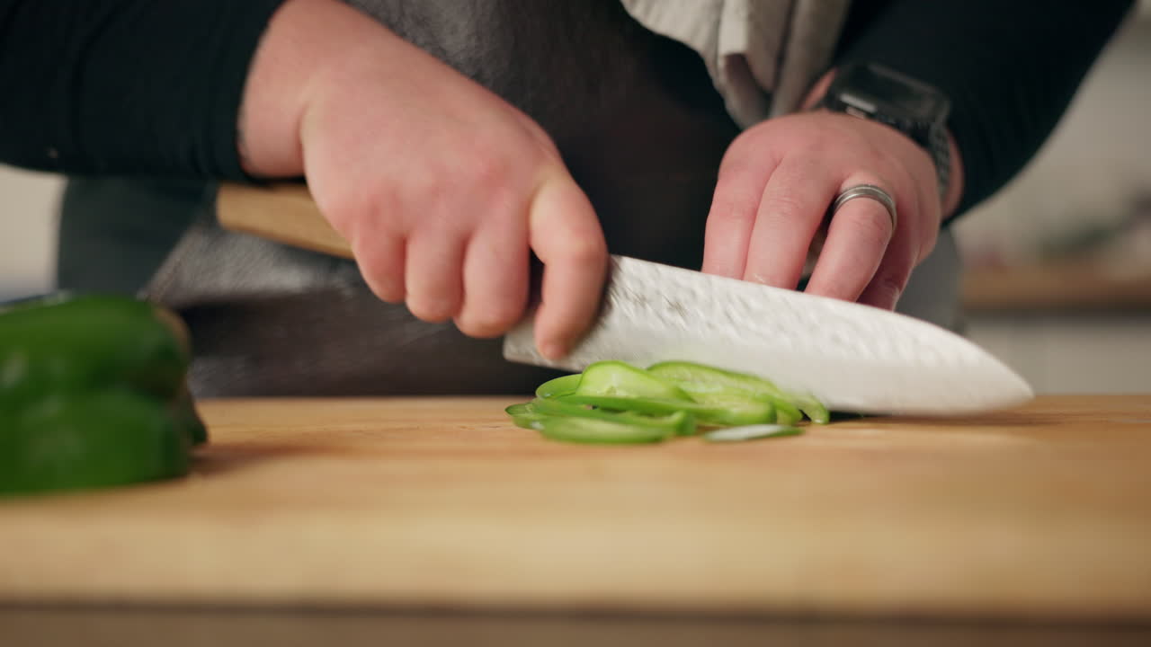 el chef cortando pimienta verde