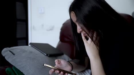 teenage girl lying on the sofa using smartphone, suffering from social media addiction