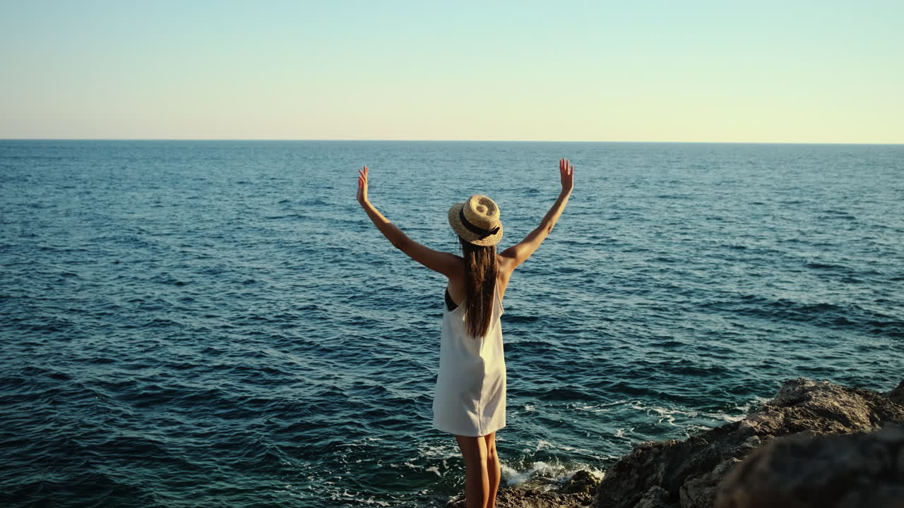 mujer disfrutando de la vista del océano desde un acantilado
