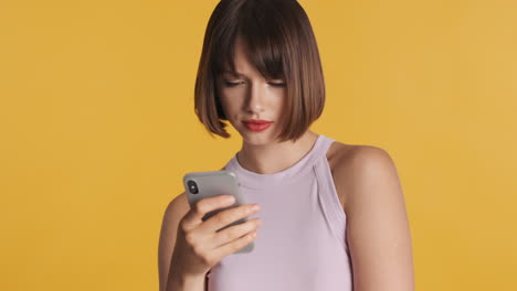 mujer molesta mirando su teléfono inteligente