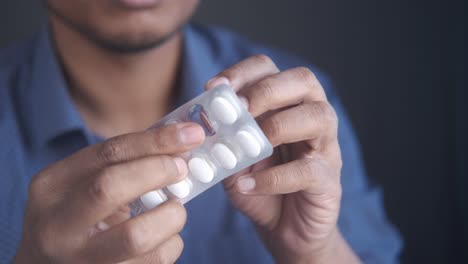 person taking pills from blister pack