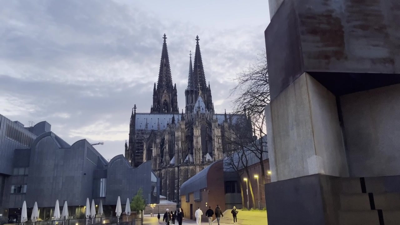 Kölner Dom om aftenen med ensartede fodgængere