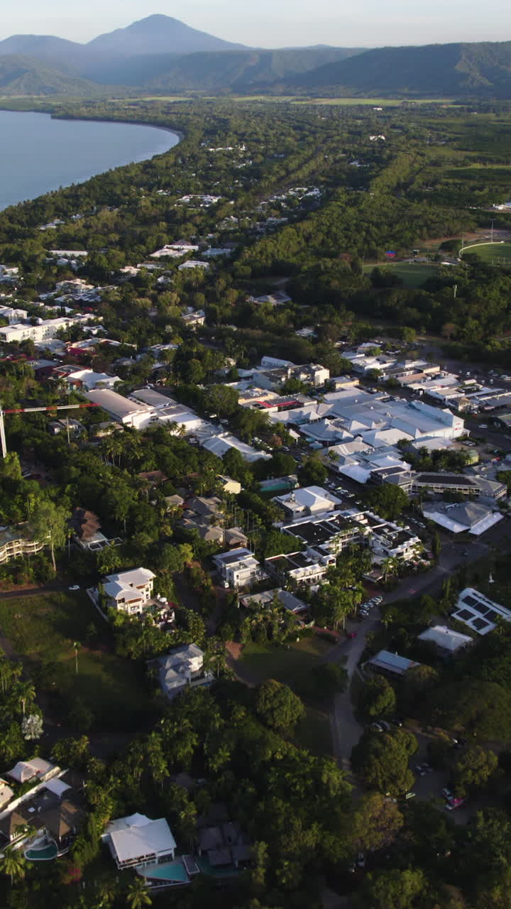 Aerial portrait flying over sunlit streets of Port Douglas, Australia, golden hour