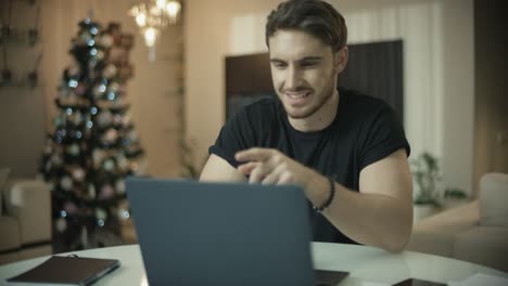 Surprised-man-looking-at-laptop-computer-screen-at-christmas-time