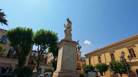 statue surrounded by historic buildings and trees