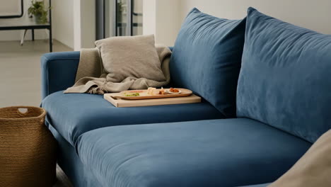 cozy blue sofa in a modern living room with snacks on a tray