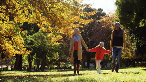 animation of burning paper over happy caucasian parents with daughter walking in park