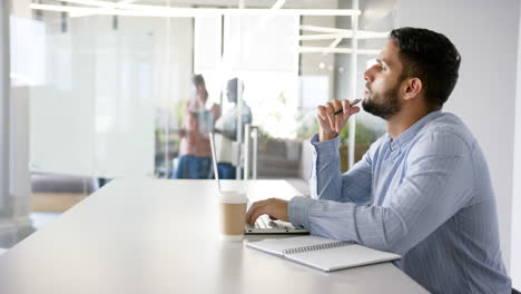 thinking deeply, man working on laptop with coffee and notepad in office, copy space