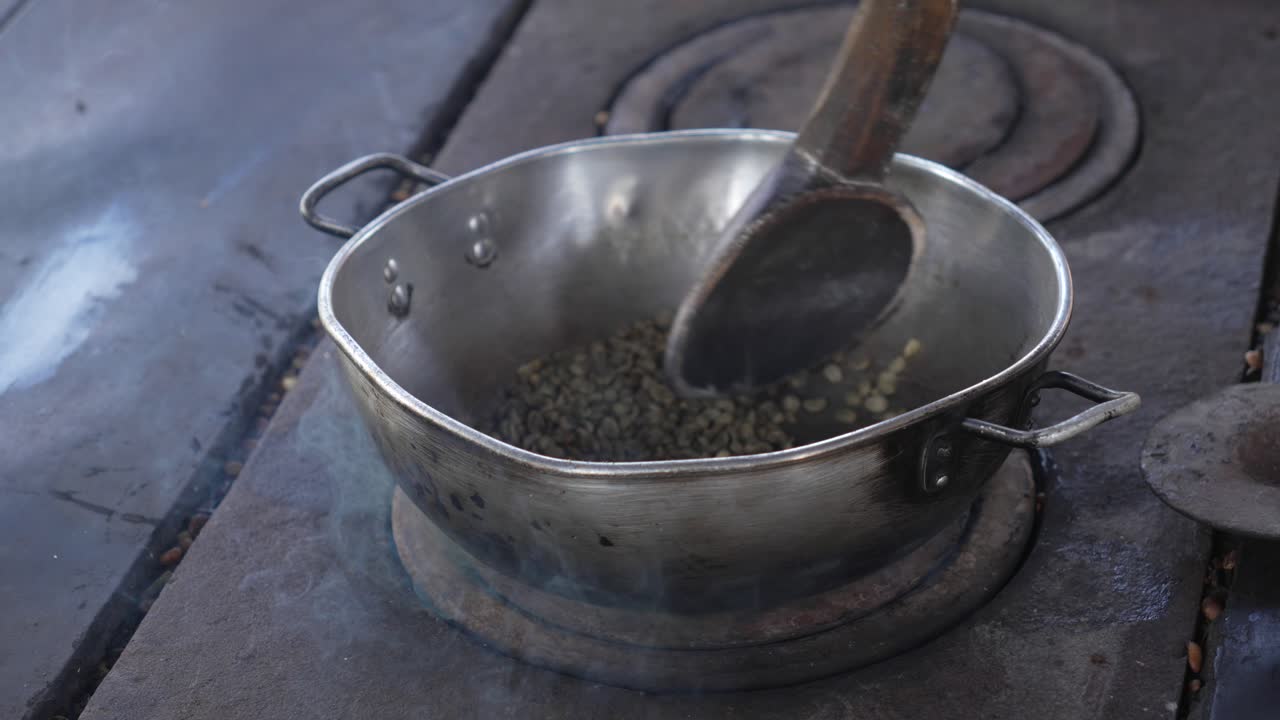 Coffee beans being roasted in a pan over a heat source in Colombia, how is made process