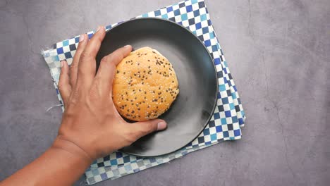 vista superior de la mano recoger una hamburguesa de carne en la mesa