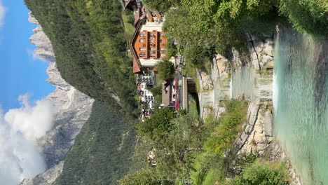 Molveno-township-with-flowing-mountain-river-in-Dolomites,-Italy,-vertical-view