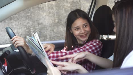 vacation time and travel, three beautiful young women cheerful travels together for a relaxing holiday. and the laughter in the car. finding directions by map.